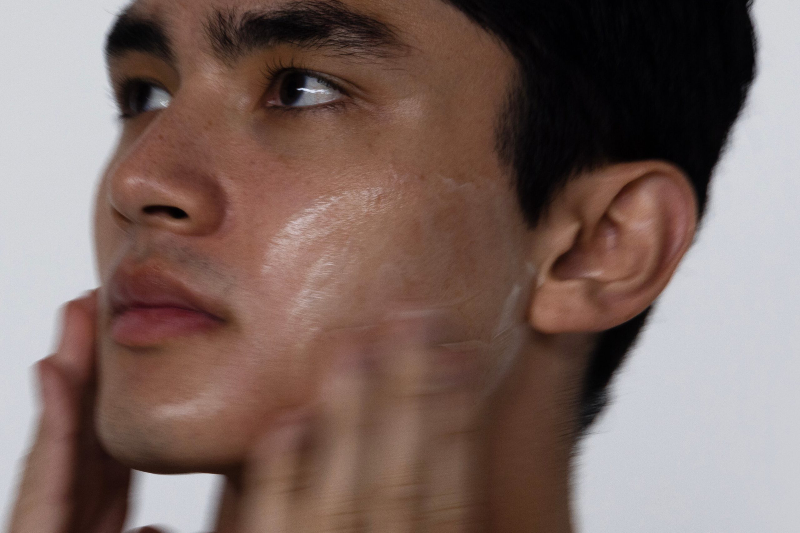 Man buffing back his skin with a gentle chemical exfoliation product.